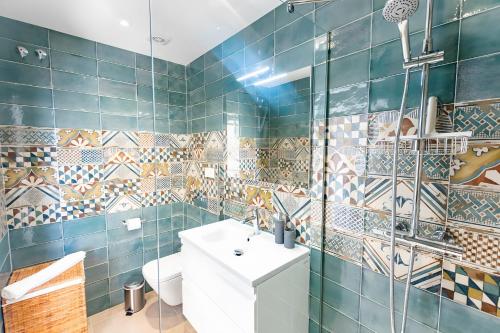 a bathroom with blue tiles and a toilet and a sink at Stunning apartment in Cómpeta in Cómpeta