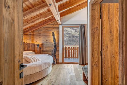 a bedroom with a bed and a large window at Lòni Lodge Vermiglio in Vermiglio