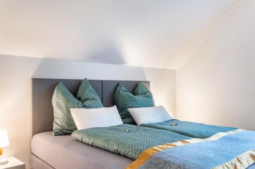 a bedroom with a bed with blue sheets and pillows at Fewo Naturblick in Wiesenthau