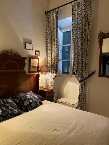 a bedroom with a bed and a window with curtains at Casa vacacional Es Port in Portocolom