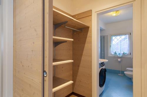 a bathroom with a closet with wooden shelves at La Casetta Gialla in Pieve di Cadore