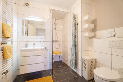 a white bathroom with a sink and a toilet at Ferienwohnung Martin Lehmann in Oberharmersbach