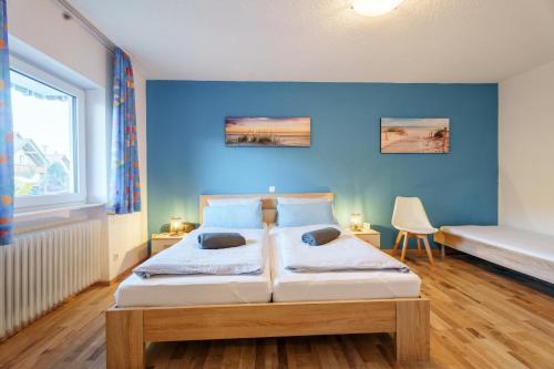 a bedroom with a bed with a blue wall at Ferienwohnung Martin Lehmann in Oberharmersbach