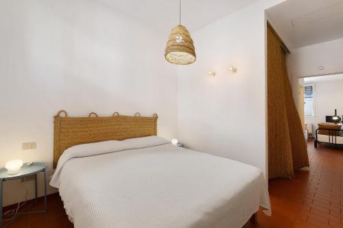 a bedroom with a white bed and a pendant light at U Canetta 1 in Pietra Ligure