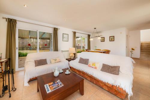 a living room with two white couches and a table at Villa Can Gaya in Alcudia