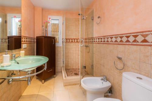 a bathroom with a sink and a toilet and a shower at Villa Can Gaya in Alcudia