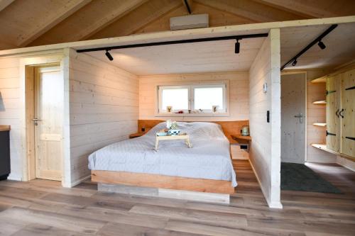a bedroom in a log cabin with a bed and a window at Panoramahisli 3 in Fischerbach