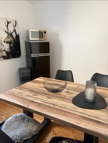 a wooden table with chairs and a microwave at Ferienwohnung Auszeit in Bad Bertrich