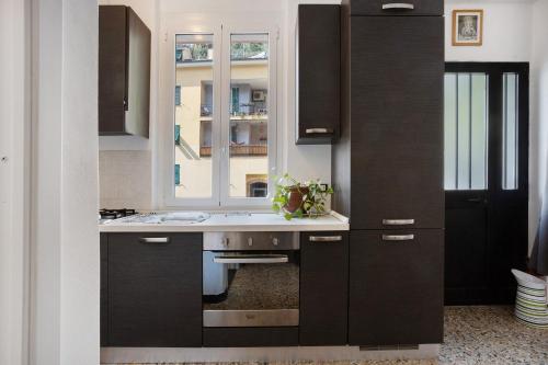 a kitchen with black cabinets and a window at Casa Luigi in Vernazza