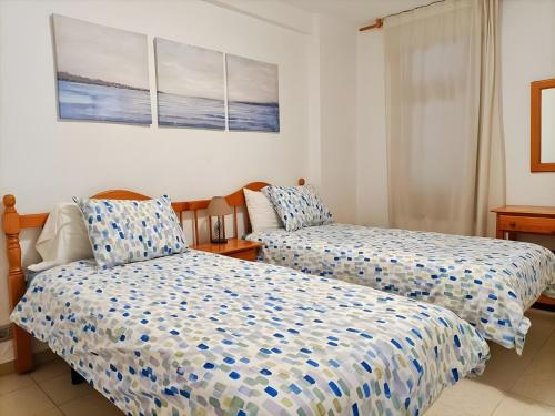 a bedroom with two beds with blue and white sheets at Casa Marazul in Playa Fañabe