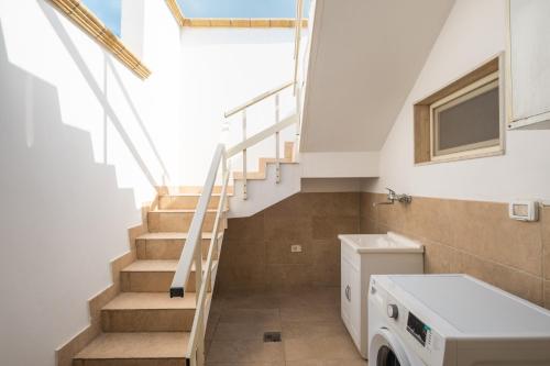 a bathroom with stairs and a washer and dryer at Narcê – Coastal Retreat in Porto Cesareo
