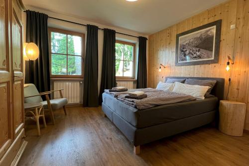 a bedroom with a bed and a table and windows at Valentin36 Apartment Geisler in Funes