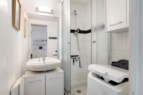 a white bathroom with a sink and a shower at M112 - L'orée Du Golf in Pornic