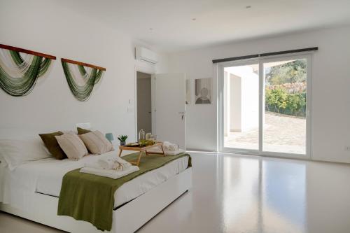 a white bedroom with a bed and a window at Villa Nilde in Triggianello