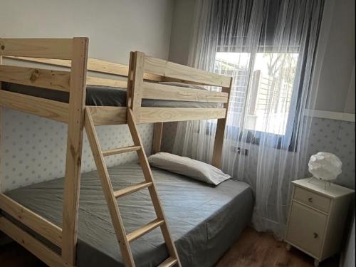 a bedroom with two bunk beds and a window at Samitier in Cambrils