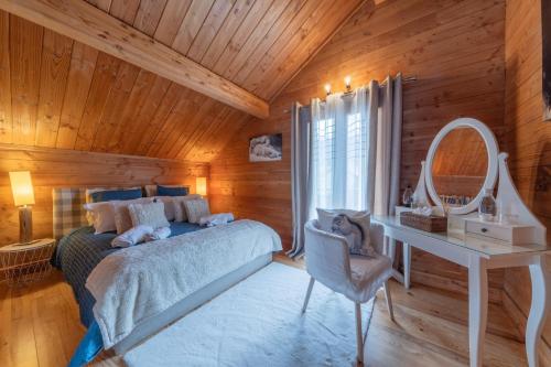 a bedroom with a bed and a desk and a mirror at Chambre D'hôte au Chalet Datcha in Briançon
