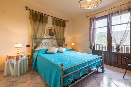 a bedroom with a bed with a blue bedspread at Appartamento Chia Grande in Chia