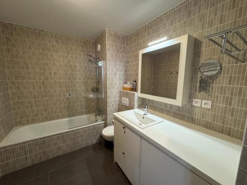 a bathroom with a sink and a tub and a toilet at Loges blanches b101 Roca immobilier in Châtel