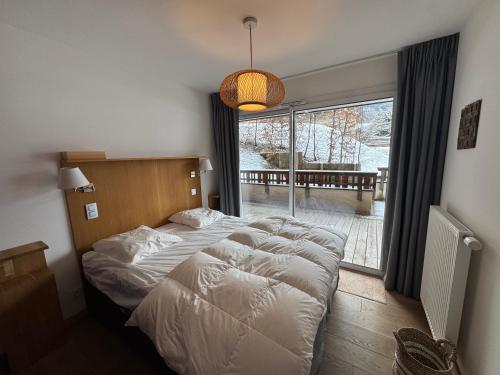 a bedroom with a large bed and a large window at Loges blanches b101 Roca immobilier in Châtel