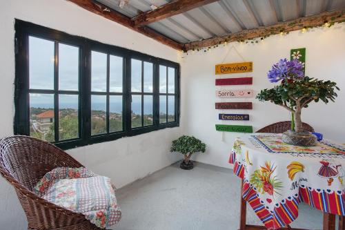 a dining room with a table and chairs and windows at Luci's House in São Jorge