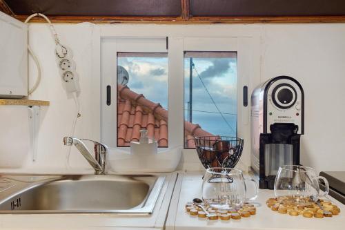 a kitchen counter with a sink and a window at Luci's House in São Jorge