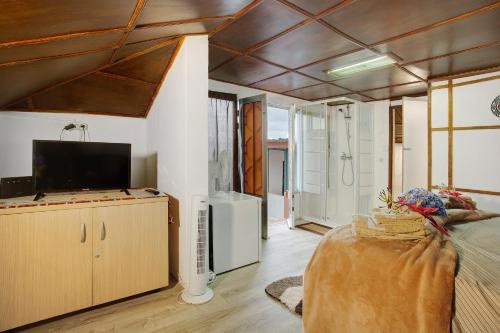 a large living room with a tv and a couch at Luci's House in São Jorge