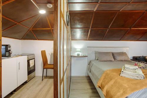a small bedroom with a bed and a kitchen at Luci's House in São Jorge