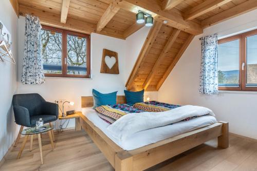a bedroom with a bed with blue pillows and a chair at Vorderbühlhof in Oppenau