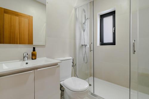 a white bathroom with a toilet and a shower at Casa Feixa Gerês in Geres