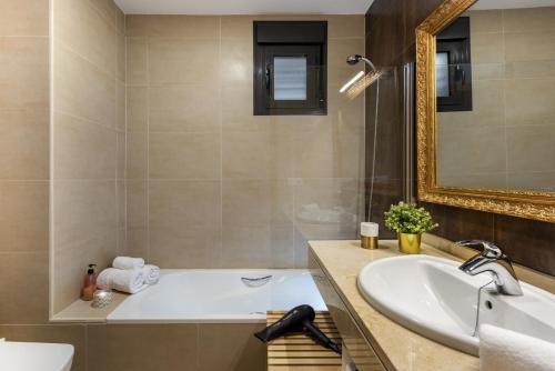 a bathroom with a tub and a sink and a mirror at Apartamento Centro con Parking in Seville