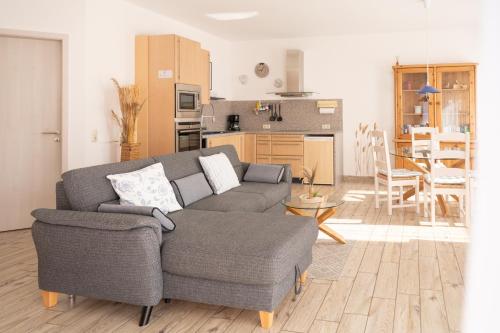 a living room with a couch and a kitchen at Bungalow Spinnaker in Ueckermünde