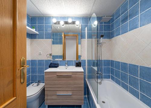 a blue tiled bathroom with a tub and a sink at Apartamento Las Joyas in Estepona