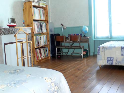 a bedroom with a bed and a desk with a chair at Les Flots Bleus Cancale in Cancale