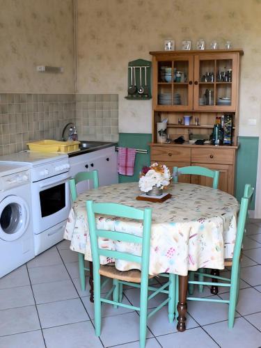 a kitchen with a table with chairs and a sink at Les Flots Bleus Cancale in Cancale