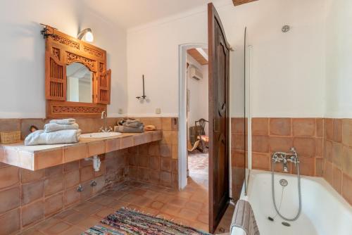 a bathroom with a tub and a sink and a mirror at Casa Roca Esporles in Esporlas