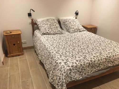 a bedroom with a bed with a black and white comforter at Papi Stop in Villarlurin