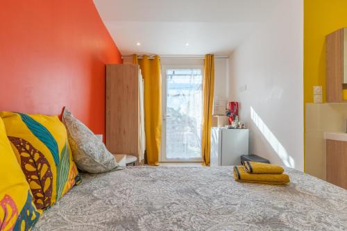 a bedroom with a large bed with an orange wall at La Dolce Vita 2 in Lambesc