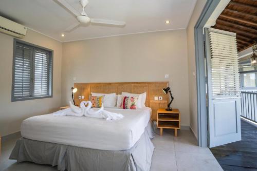 a bedroom with a large bed with white sheets at The Peacock Inn in Ubud