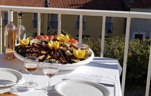 a table with a bowl of food and glasses of wine at Le Bellavista T2 Cassis Emplacement in Cassis