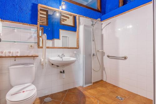 a bathroom with a toilet and a sink at El Cobertizo in La Zubia