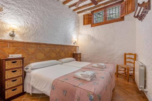 a bedroom with a bed and a desk and a chair at El Cobertizo in La Zubia