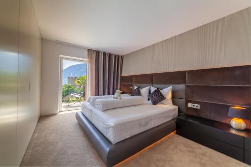 a bedroom with a large bed and a large window at Levita Living Anima in Tirolo