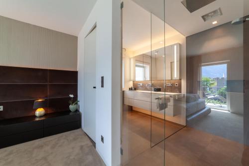 a bathroom with a glass shower and a sink at Levita Living Anima in Tirolo