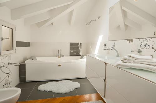 a white bathroom with a sink and a tub at Appartamento Villa Antonia in Marina di Andora