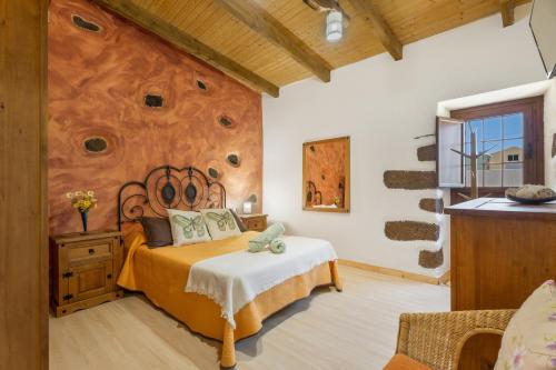 a bedroom with a bed with a rock wall at vv - La Casa Verde in Las Casas