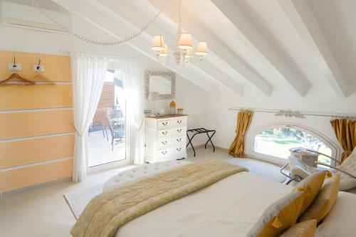 a white bedroom with a large bed and a window at Appartamento Villa Antonia in Marina di Andora