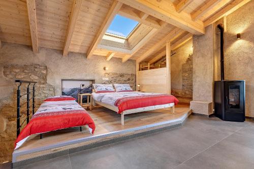 two beds in a large room with wooden ceilings at Chalet Al Volt in Tremosine Sul Garda