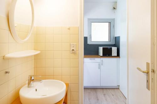 a small bathroom with a sink and a mirror at Les Mimosas - Appartement 06 in Cazaubon