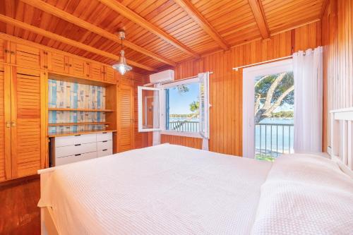 a bedroom with a white bed and two windows at Villa Lucia in Portocolom