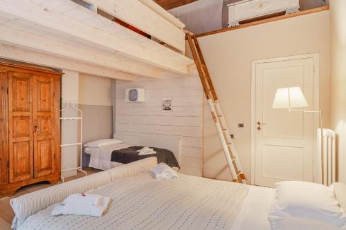 a bedroom with two beds and a ladder at L'affresco in Via Guinigi in Lucca